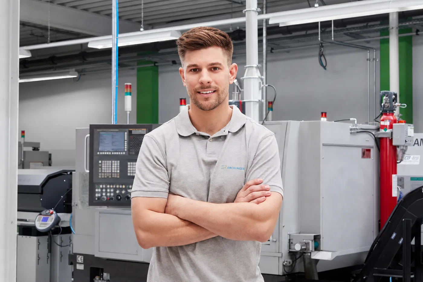 An employee in front of a CNC lathe on the production floor