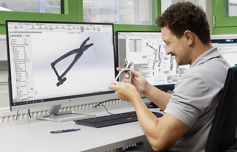 Konstrukteur bei Erchinger prüft ein chirurgisches Instrument im Abgleich mit der CAD-Konstruktion — Entwicklung
