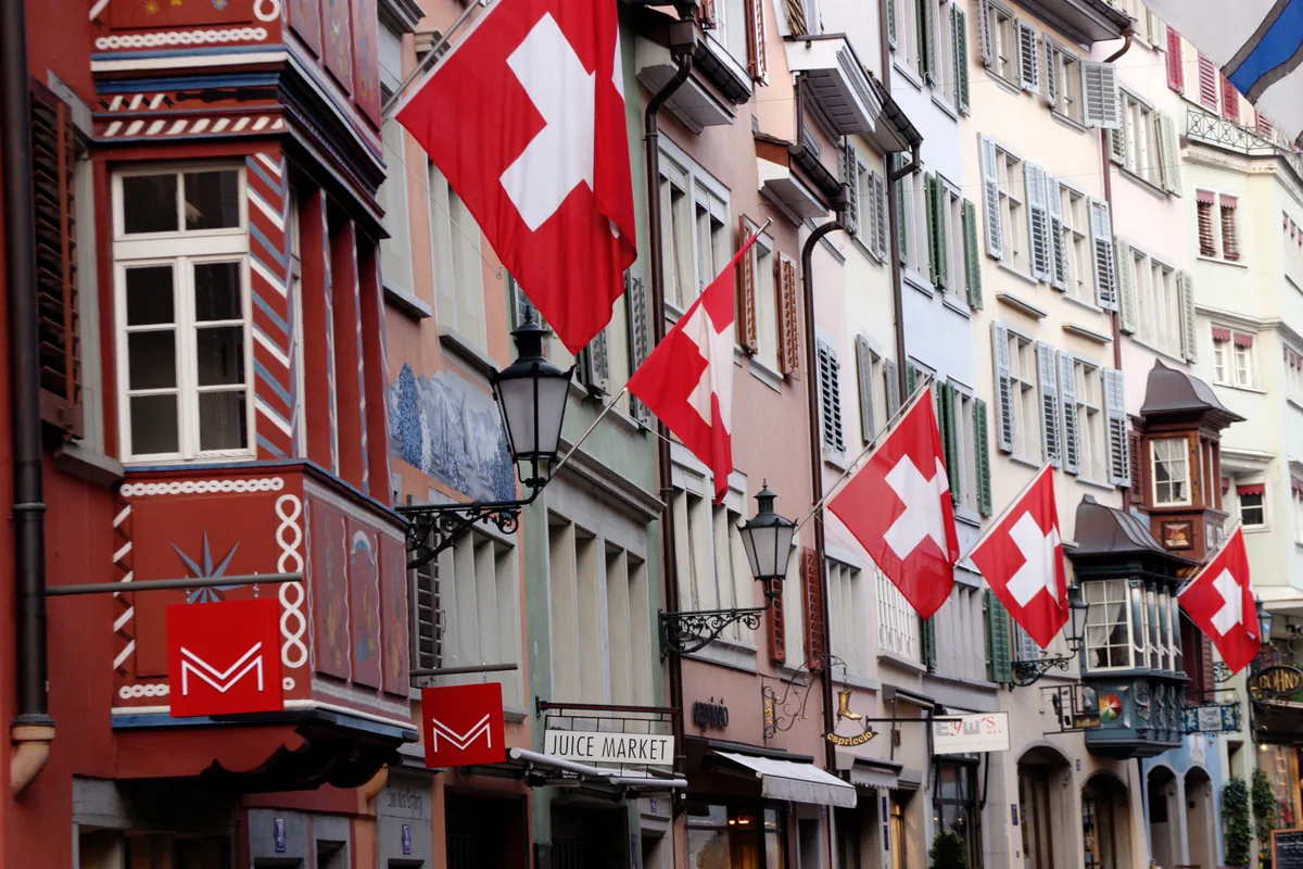 Altstadtgasse in Zürich mit Schweizer Flaggen an den Fassaden